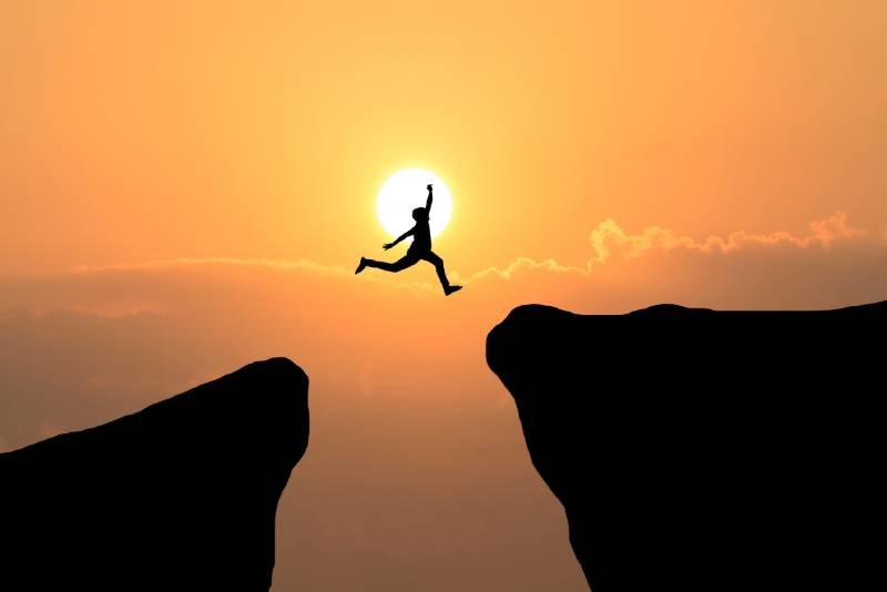 courage-man-jump-through-gap-hill-business-concept-idea